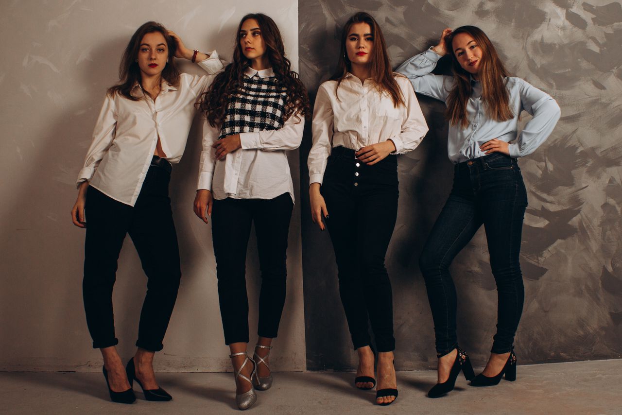 gallery-05 A group of fashionable women posing in a studio wearing smart casual outfits.