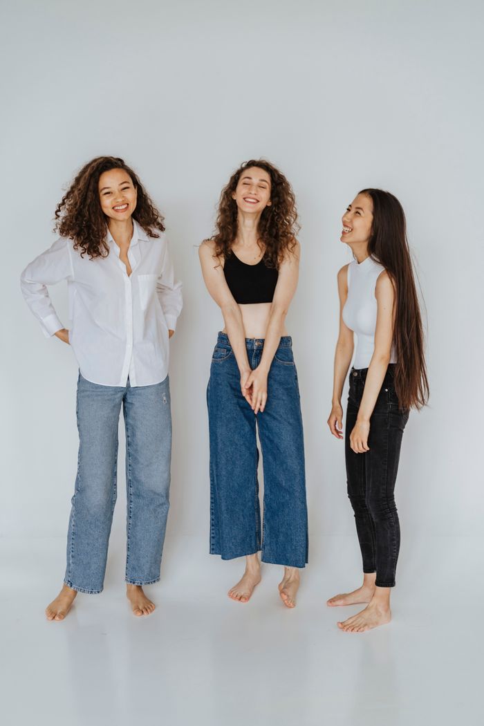gallery-03 Group of young women posing joyfully in studio, showcasing fashion and diversity.